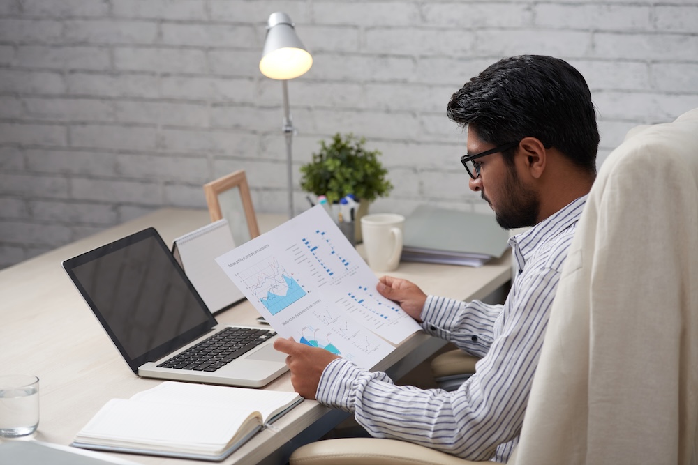a guy sitting at a desk going over paper work